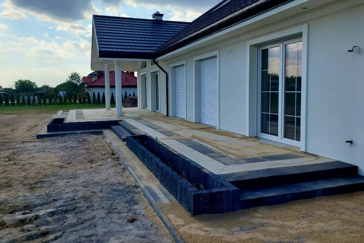 Taras wzdłuż domu z kostki tarasowej